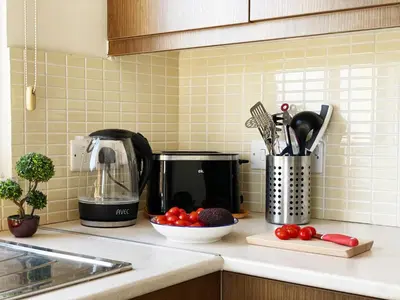 a kitchen counter with a coffee maker and a bowl of tomatoes at Stylish 2BR Apartment with Balcony and Parking near Saint Lazarus and Finikoudes Beach in Larnaka