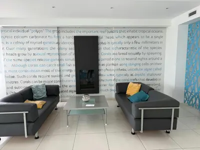 a living room with two couches in front of a wall at Too Coool Studio Apartment Coralli Resort in Protaras