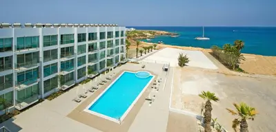 an overhead view of a hotel with a swimming pool and the ocean at Too Coool Studio Apartment Coralli Resort in Protaras