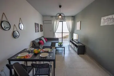a living room with a table and a couch at Anteia's Seaview Suite just steps from Finikoudes Beach Larnaca in Larnaka