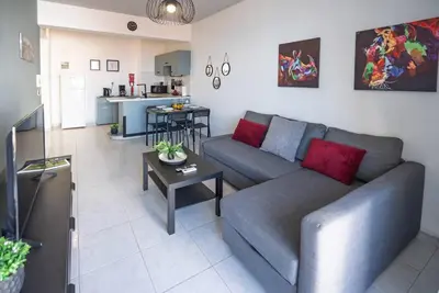 a living room with a couch and a table at Anteia's Seaview Suite just steps from Finikoudes Beach Larnaca in Larnaka