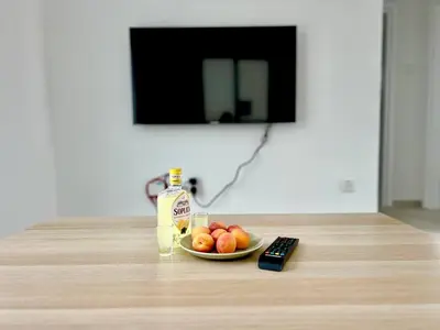 a plate of fruit on a table with a remote control at Protaras Cozy2bedroom Apartment in Paralimni
