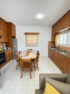a kitchen with a table and chairs in a room at Makenzy Mermaid 2 Bedroom Apartment in Larnaka
