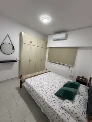 a bedroom with a bed with a green pillow on it at Makenzy Mermaid 2 Bedroom Apartment in Larnaka