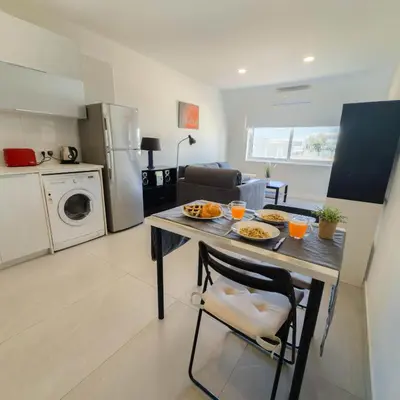 a kitchen and living room with a table with food on it at Azure Retreat in Ayia Napa