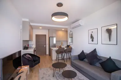 a living room with a couch and a kitchen at Crown Hall Suites in Limassol