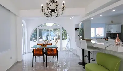 a kitchen with a table with chairs and a dining room at Landina villa in Protaras