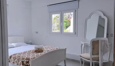 a bedroom with a bed and a mirror and a chair at Landina villa in Protaras