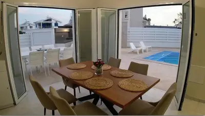 a dining room with a table and chairs at Celestial Villa in Ayia Napa