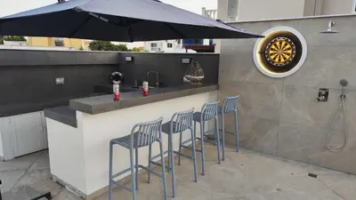 a bar with four chairs and an umbrella at Celestial Villa in Ayia Napa