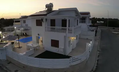 a large white house with a fence around it at Celestial Villa in Ayia Napa