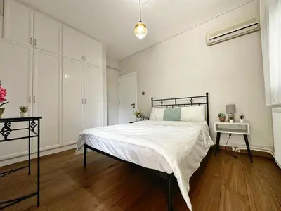a bedroom with a large bed and a table at Cheerful and cozy Bungalow with pool and fireplace in Athalassa