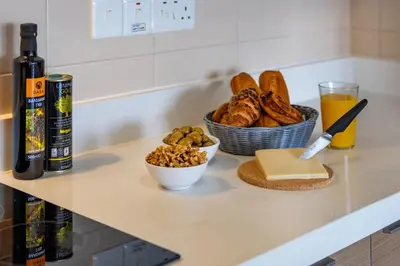 a counter with a bowl of bread and a basket of cheese at Marathon Beach Apartment - Sea View, Shared Pool in Limassol
