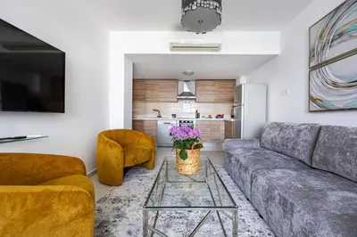 a living room with a couch and a table at Marathon Beach Apartment - Sea View, Shared Pool in Limassol