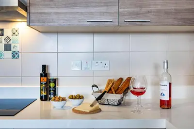 a counter with a bottle of wine and a glass at Marathon Beach Apartment - Sea View, Shared Pool in Limassol