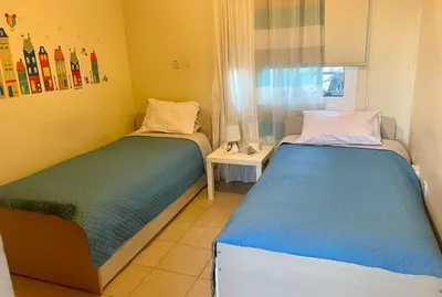 two twin beds in a room with a window at Charming Oroklini Penthouse with Ocean Views and Private Parking in Voroklini