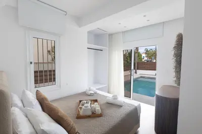 a white living room with a couch and a pool at EvelMar Villa in Protaras