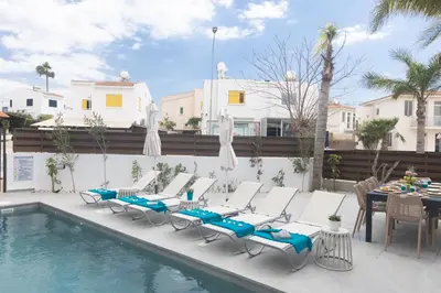 a swimming pool with chairs and a table and a table and a pool at EvelMar Villa in Protaras