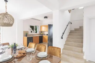 a dining room with a table and chairs and a staircase at EvelMar Villa in Protaras