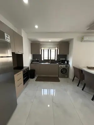 a large kitchen with a sink and a table at Sia-Serenity Finikoudes Apartment in Larnaka