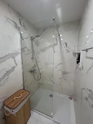 a bathroom with a shower with a glass door at Sia-Serenity Finikoudes Apartment in Larnaka