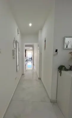 a hallway with white walls and a white floor at Sia-Serenity Finikoudes Apartment in Larnaka