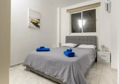 two blue bags sitting on a bed in a bedroom at Ariel 3 bed Apartment in Larnaka