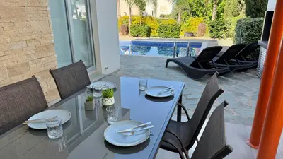 a blue table and chairs on a patio at Too Coool Villa Milos Lifestyle in Protaras