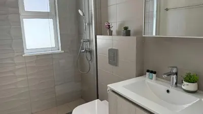a white bathroom with a shower and a sink at Too Coool Villa Milos Lifestyle in Protaras