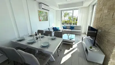 a dining table and chairs in a living room at Too Coool Villa Milos Lifestyle in Protaras