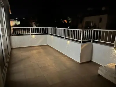 a white balcony with lights on it at night at Emerald Luxe in Ayia Napa