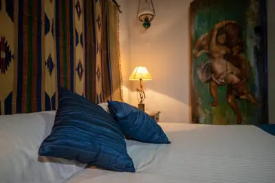 a bed with two blue pillows on top of it at Apanemia Inn House in Lofou