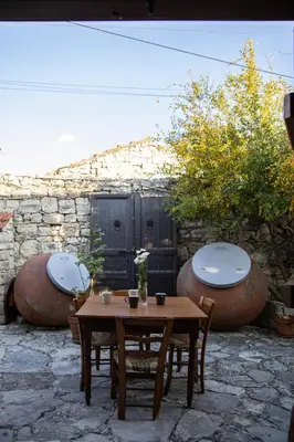 a patio with a table and two large pots at Apanemia Inn House in Lofou