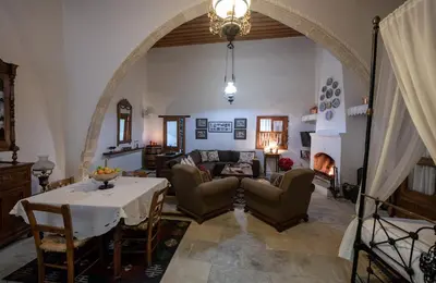 a living room with a table and a fireplace at Apanemia Inn House in Lofou