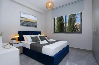 a bedroom with a blue and white bed and a window at Villa Camellia - 3bed Bungalow large pool in Protaras