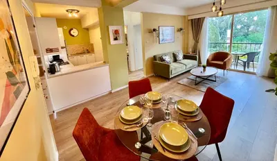 a dining room and living room with a table and chairs at Tropical Cozy 1 - Bedroom Apartment in Limassol