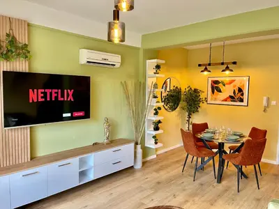 a living room with a television and a table with chairs at Tropical Cozy 1 - Bedroom Apartment in Limassol