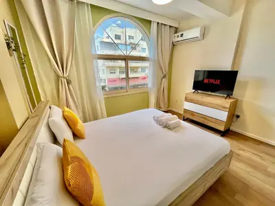 a bedroom with a bed and a tv and a window at Tropical Cozy 1 - Bedroom Apartment in Limassol