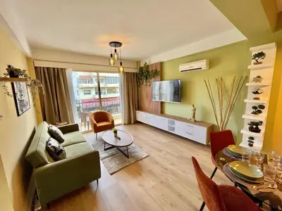 a living room with a couch and a table and a television at Tropical Cozy 1 - Bedroom Apartment in Limassol