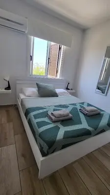 a bedroom with a large bed with two pillows on it at HANA Holiday house in Ayia Napa