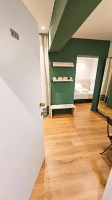 a room with a green wall and a room with a bed at The Colors of Larnaca in Larnaka