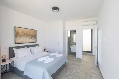 a white bedroom with a large bed with towels on it at Protaras Aqua Villa AQ05 in Protaras