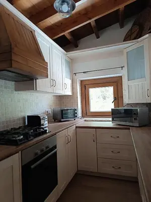 a kitchen with white cabinets and a window at Stone Garden Oasis Cottage in Limassol