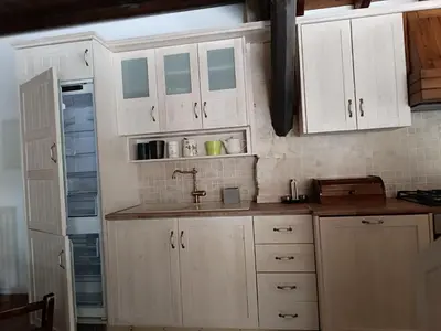 a kitchen with white cabinets and a sink and a refrigerator at Stone Garden Oasis Cottage in Limassol