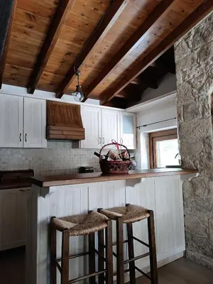 a kitchen with a counter and stools in a room at Stone Garden Oasis Cottage in Limassol