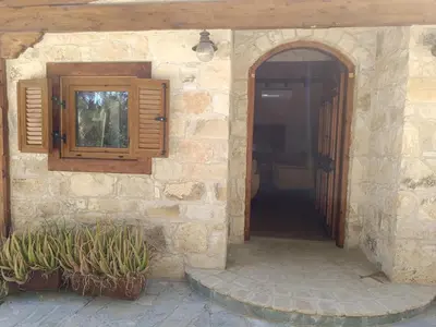 an entrance to a stone house with a door and a window at Stone Garden Oasis Cottage in Limassol