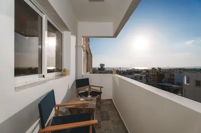 two chairs and a table on a balcony with a view at Modern seaview apartment in the heart of Agia Napa in Ayia Napa