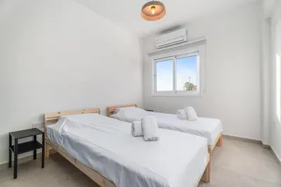 two beds in a room with a window at Modern seaview apartment in the heart of Agia Napa in Ayia Napa