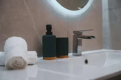 a bathroom sink with a bottle of soap and towels at Modern seaview apartment in the heart of Agia Napa in Ayia Napa
