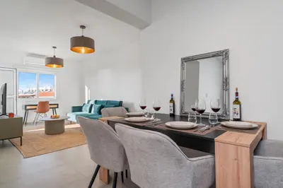 a living room with a dining room table with wine glasses at Modern seaview apartment in the heart of Agia Napa in Ayia Napa